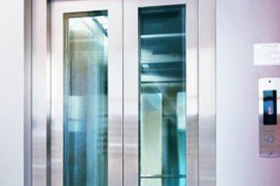 The elevator features smooth sliding doors with vertical glass windows, allowing partial visibility while maintaining privacy.